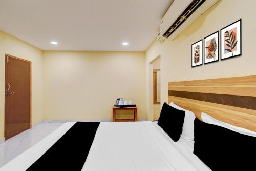 a bedroom with a white bed with black pillows at Super Collection O Victoria Memorial Metro Station Formerly Shanthaa Residency in Surūrnagar