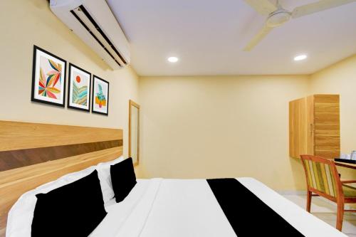 a bedroom with a black and white bed and a desk at Super Collection O Victoria Memorial Metro Station Formerly Shanthaa Residency in Surūrnagar