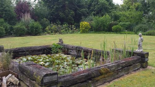 a garden with a pond with a statue in it at Vakantieverblijf Strandgaper in Oostduinkerke