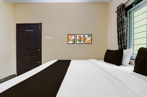 a bedroom with a large white bed and a window at Collection O Tirupati Railway Junction Formerly Y Stay Home Stay in Tirupati