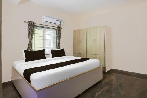 a bedroom with a large white bed and a window at Collection O Tirupati Railway Junction Formerly Y Stay Home Stay in Tirupati