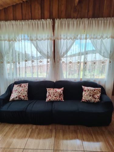a blue couch in front of a large window at Cabaña doña Alicia in El Copey