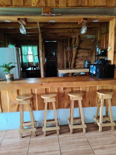 a wooden bar with stools in a kitchen at Cabaña doña Alicia in El Copey