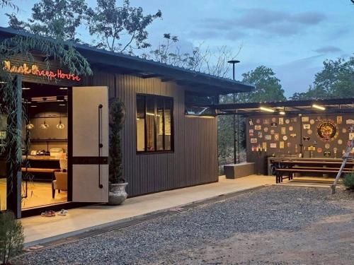 a building with a table and a bench outside at Black Sheep House Khaoyai by ALPHATEL PARTNER in Pong Talong