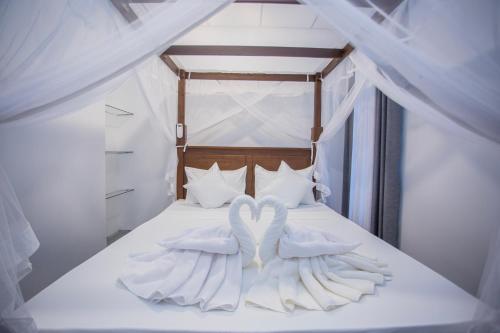 two swans are sitting on top of a bed at Villa Lisini in Talpe