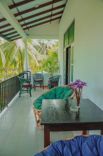 a patio with a table and chairs on a porch at Villa Gaetano Unawatuna in Unawatuna