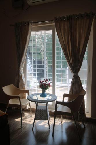 a room with a table and chairs and a window at Beachside Bliss - Villa 32 in Kilpettai