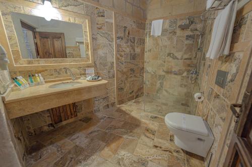 a bathroom with a sink and a toilet and a mirror at Zara Cave Hotel in Goreme