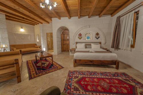 a bedroom with a bed and a couch and a table at Zara Cave Hotel in Goreme