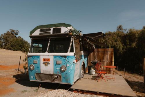 a blue and white bus parked in a lot at R&R Bus Retreat in Wellington Mills