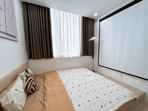 a bed in a room with a large window at Châu Giang Homestay, Nera Garden Huế in Thôn Văn Dương