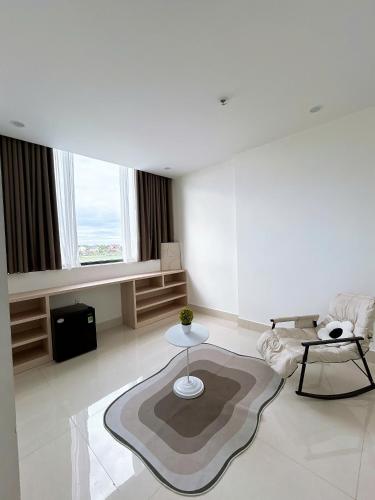 a white living room with a couch and a table at Châu Giang Homestay, Nera Garden Huế in Thôn Văn Dương