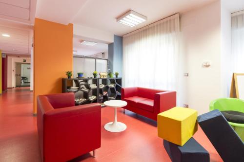 a waiting room with chairs and a table at Hotel Sharing in Turin