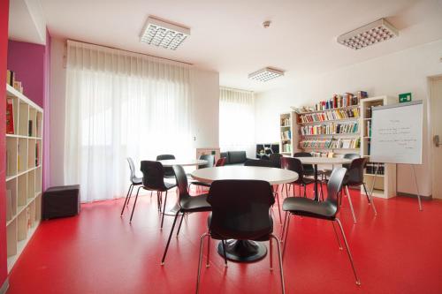 a classroom with tables and chairs in a library at Hotel Sharing in Turin