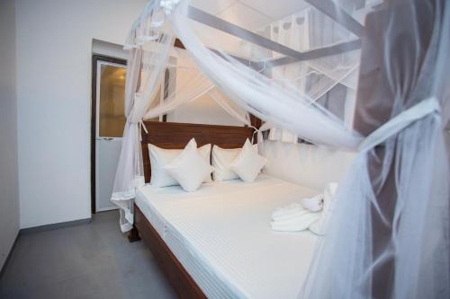 a bedroom with a bed with white sheets and pillows at Villa Lisini in Talpe