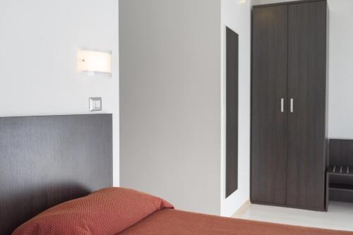 a bedroom with a bed with a closet and a door at Hotel Sharing in Turin