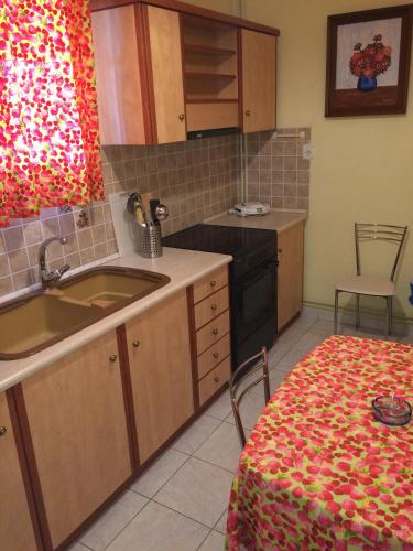 a kitchen with a sink and a stove and a table at Villaggio Verde in Laganas