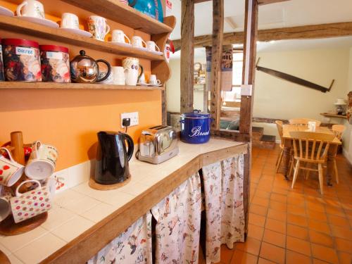 una cucina con bancone e macchinetta del caffè di Rye Court Cottage a Birtsmorton