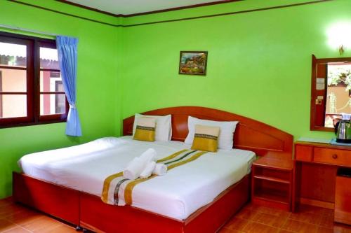 a green bedroom with a bed with a stuffed animal on it at Island View Bungalows in Choeng Mon Beach