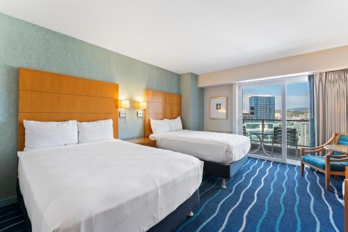 a hotel room with two beds and a balcony at Ala Moana Hotel Sleeps 4 near beach in Honolulu