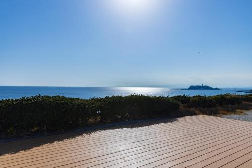 a wooden deck with the ocean in the background at Kamakura Prince Hotel in Kamakura