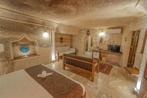 a bedroom with a bed and a living room at Zara Cave Hotel in Goreme