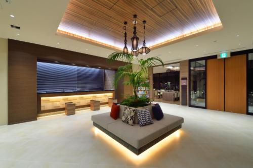 a lobby with a couch in the middle of a building at Almont Hotel Naha Kenchomae in Naha
