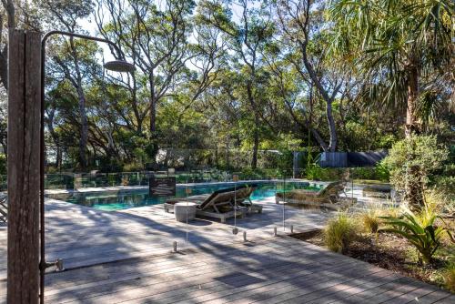 a swimming pool with a wooden deck next to a resort at Bangalay Villa 15 just Steps from Seven Mile Beach in Shoalhaven Heads