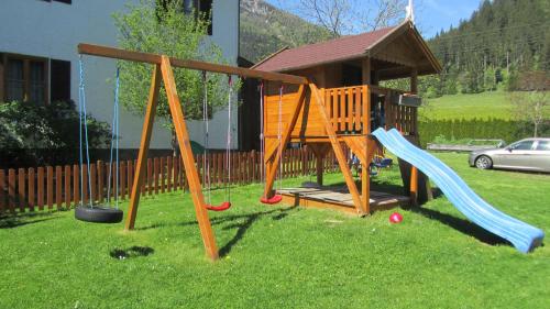 einen Spielplatz mit zwei Schaukeln und einem Pavillon in der Unterkunft Large cozy apartment Grubweg 130 qm in Sankt Martin am Tennengebirge