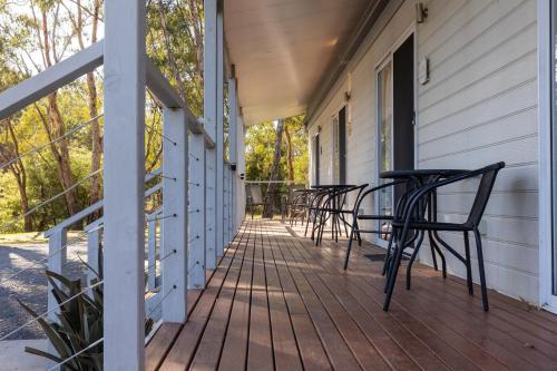 a porch with chairs and tables on a house at Yea Riverside Caravan Park in Yea