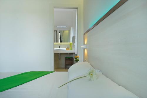 a bedroom with a white bed with a flower on it at Viverenumana in Numana