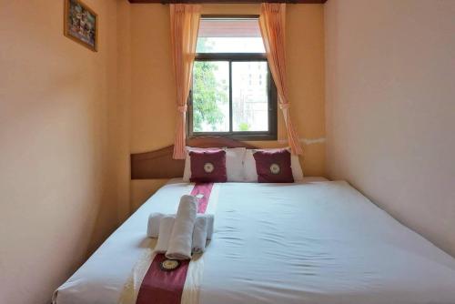 a small bedroom with a bed with a window at Island View Bungalows in Choeng Mon Beach