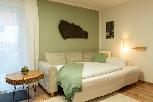a living room with a bed and a table at Gemütliche Ferienwohnung "Zum Kalten Feld" in Schwäbisch Gmünd