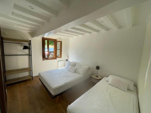 a bedroom with two beds and a window at Maison à la campagne in Auvilliers