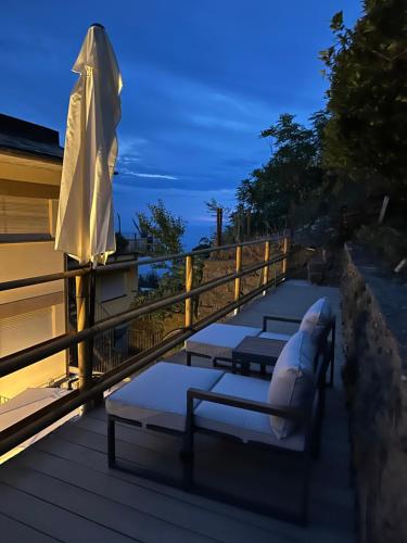 a deck with an umbrella and lounge chairs and an umbrella at Cloud Nine in Riomaggiore