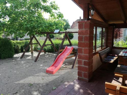 a playground with a red slide in a building at Restaurace - penzion Bavorský dvůr in Sezemice