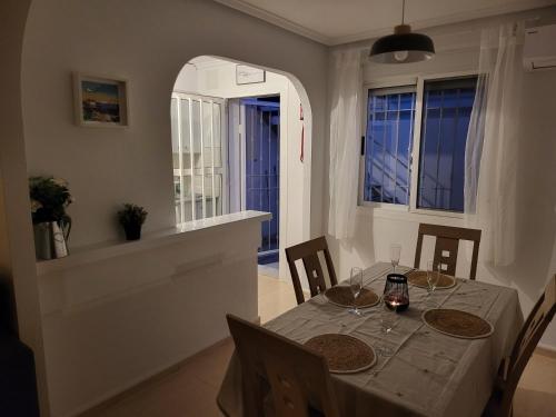 a dining room with a table and chairs and a window at Casa Lily in Mazarrón