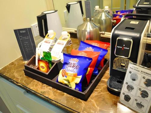 a counter with a tray of food and a microwave at Jinjiang Metropolo Hotel Classiq YMCA People Square in Shanghai