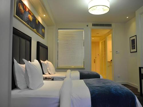 a hotel room with two beds and a window at Jinjiang Metropolo Hotel Classiq YMCA People Square in Shanghai