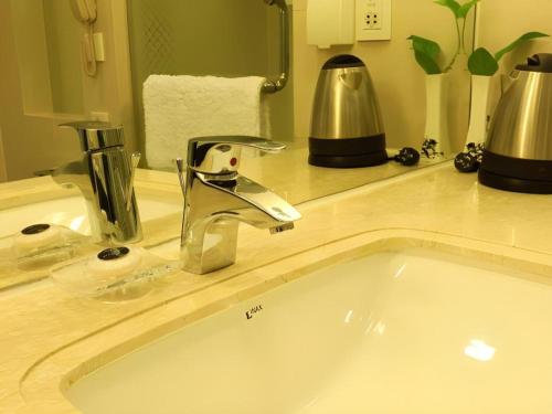 a bathroom sink with a silver faucet on a counter at Jinjiang Metropolo Hotel Classiq YMCA People Square in Shanghai