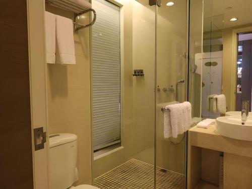 a bathroom with a shower and a toilet and a sink at Jinjiang Metropolo Hotel Classiq YMCA People Square in Shanghai