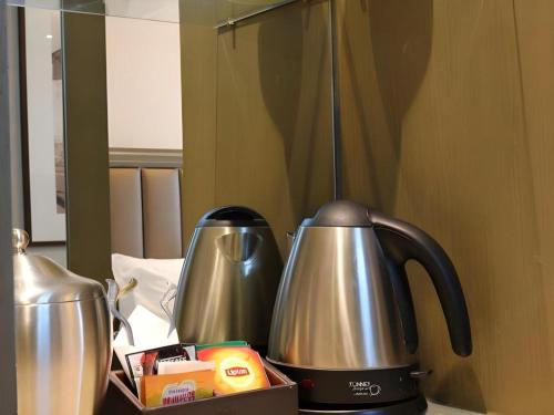 two coffee pots sitting on top of a counter at Jinjiang Metropolo Hotel Classiq YMCA People Square in Shanghai