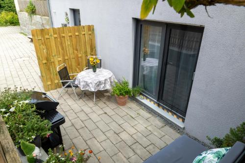 a small patio with a table and a window at Gemütliche Ferienwohnung "Zum Kalten Feld" in Schwäbisch Gmünd