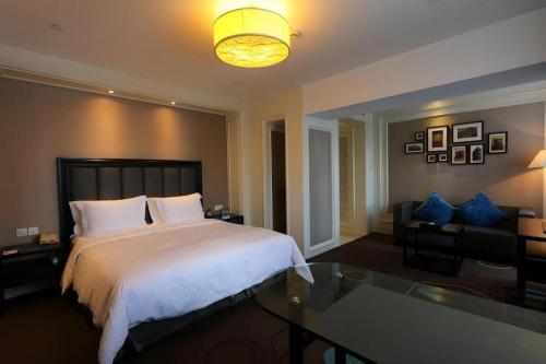 a bedroom with a large bed and a glass table at Jinjiang Metropolo Hotel Classiq YMCA People Square in Shanghai