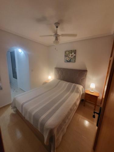 a bedroom with a large bed with two lamps on it at Casa Lily in Mazarrón