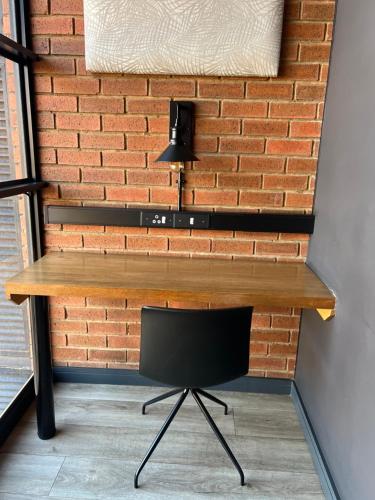 a desk with a chair in front of a brick wall at The Lagoon in Pretoria