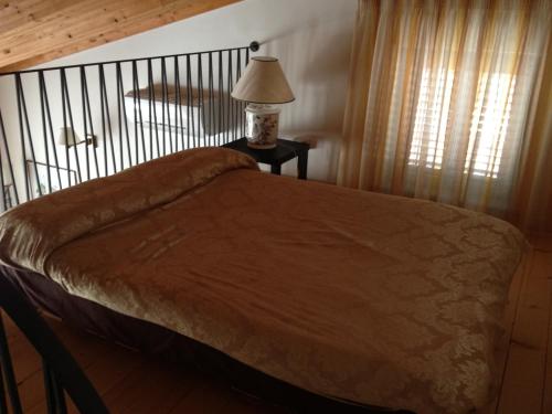a bed in a bedroom with a lamp on a table at Le dimore Al Vecchio Teatro in Ortona