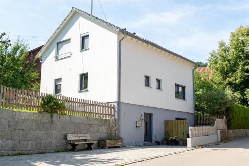 a white house with a fence in front of it at Gemütliche Ferienwohnung "Zum Kalten Feld" in Schwäbisch Gmünd