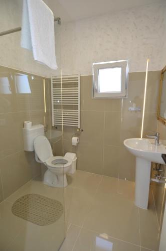 ein Badezimmer mit Toilette und Waschbecken in der Unterkunft Casa Simone in Costinești