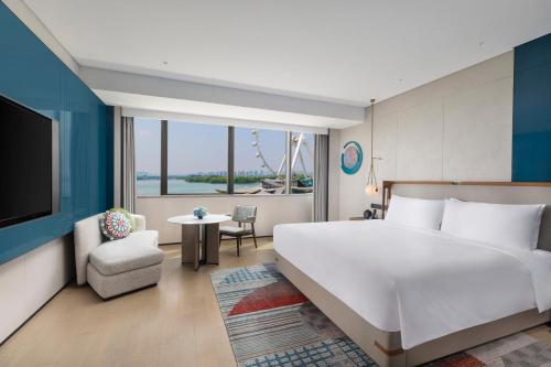 a bedroom with a large white bed and a tv at Hotel Indigo Suzhou Jinji Lake by IHG in Suzhou